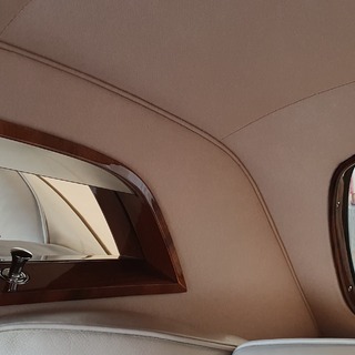 Feine Details des restaurierten Interieurs mit Leder, Holz und präzise verarbeitetem Dachhimmel. Die sorgfältige Ausführung bringt die zeitlose Eleganz des Rolls-Royce Silver Cloud besonders zur Geltung.