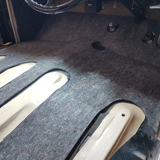 Der Fahrzeugboden des Rolls-Royce Silver Cloud nach der Demontage der alten Teppiche mit der neu angefertigten D�mmung f�r den Fussraum. Die Fl�che wurde vorab gereinigt und vorbereitet, damit die neue D�mmung und der Teppich sp�ter passgenau eingebaut werden k�nnen.
