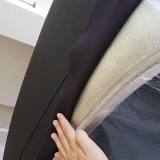 Das Kunstleder wird aufgezogen: Nach der Vorbereitung beginnt das eigentliche Beziehen des Daches. Das schwarze Kunstleder wird sorgf�ltig positioniert und Schritt f�r Schritt an die Form des Jaguar angepasst. Dabei muss das Material gleichm�ssig anliegen und sauber �ber Rundungen und Kanten gef�hrt werden.